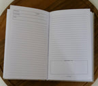 Open notebook with lined pages on a wooden surface