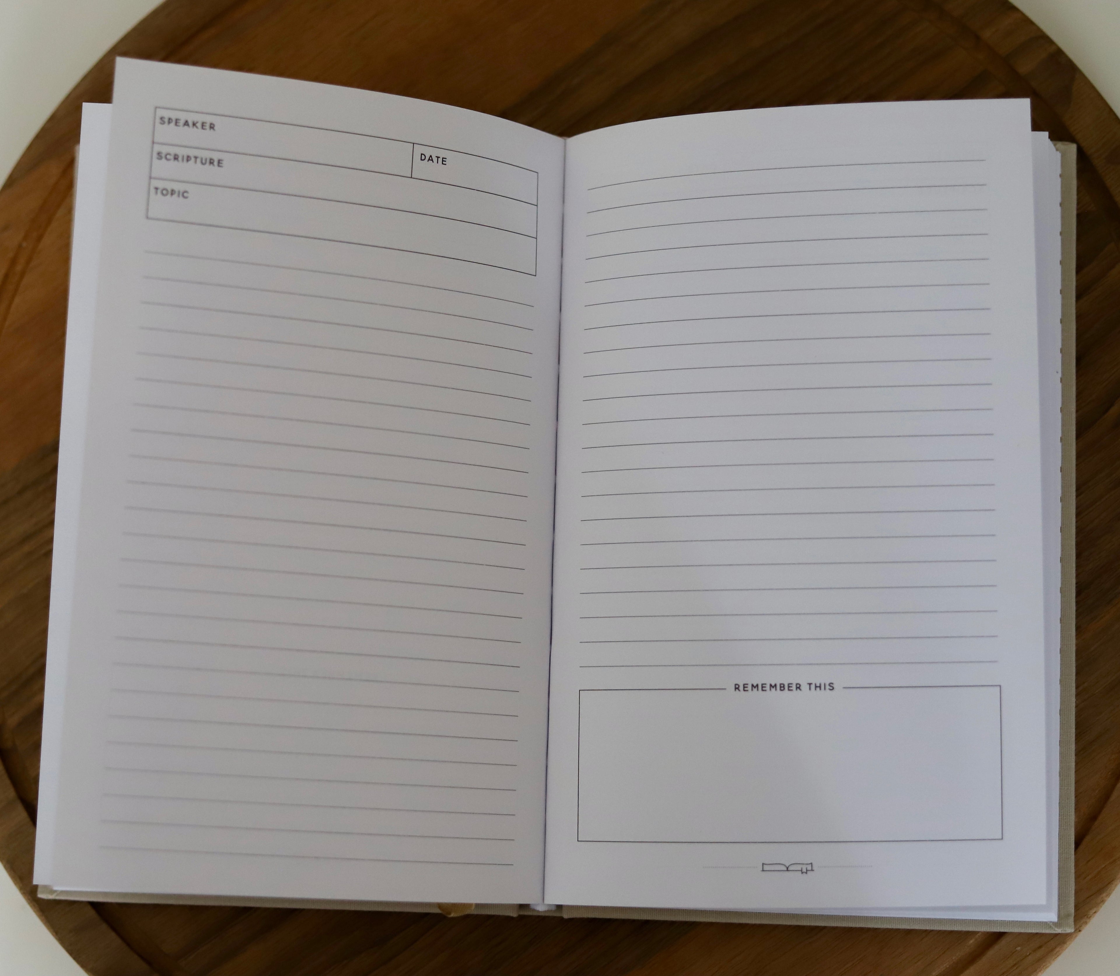 Open notebook with lined pages on a wooden surface